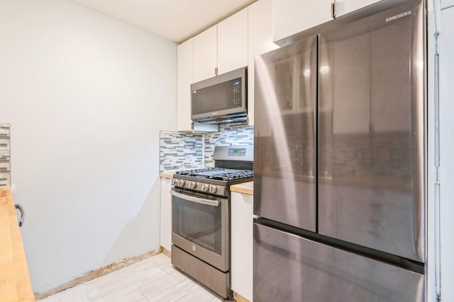 kitchen featuring white cabinets, backsplash, and appliances with stainless steel finishes