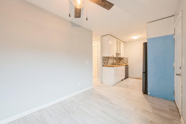 kitchen featuring white cabinetry, sink, appliances with stainless steel finishes, backsplash, and wood counters