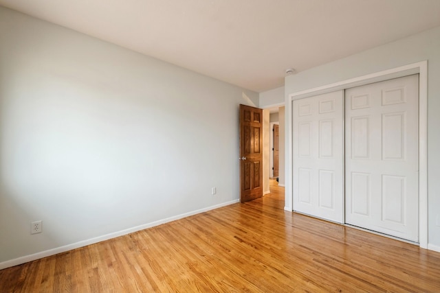 unfurnished bedroom featuring light wood-type flooring and a closet