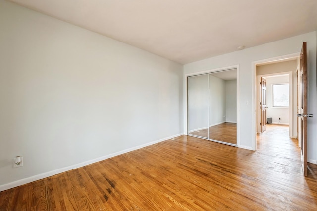 unfurnished bedroom with hardwood / wood-style floors and a closet