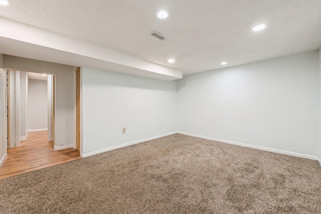 basement featuring a textured ceiling and carpet