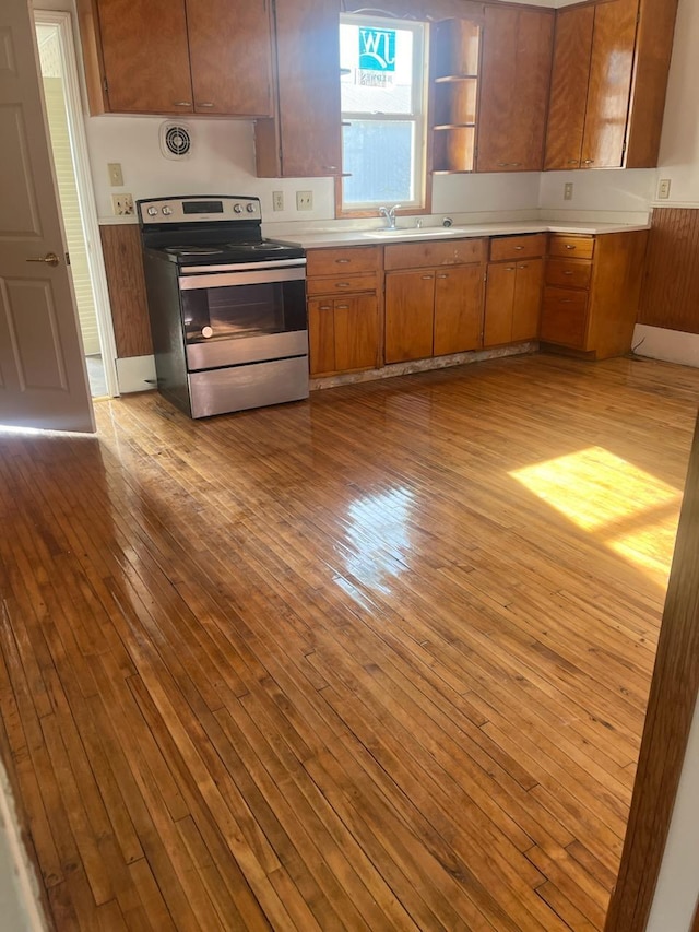 kitchen featuring light hardwood / wood-style flooring, stainless steel range with electric stovetop, and sink