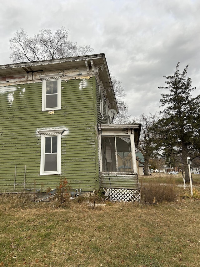 view of property exterior featuring a yard and a sunroom