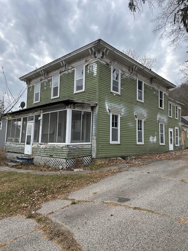 view of side of home featuring a sunroom