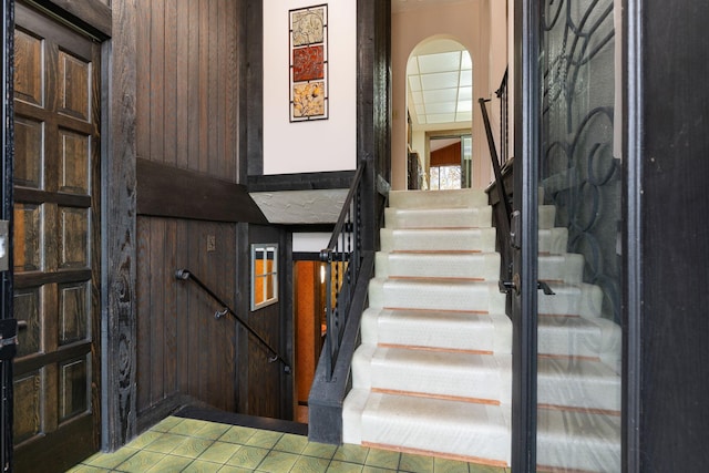 interior space featuring tile patterned flooring and wooden walls