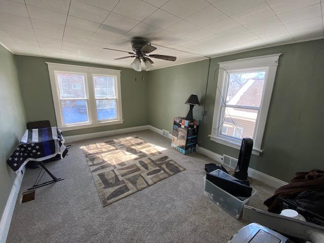 living area with carpet flooring and ceiling fan