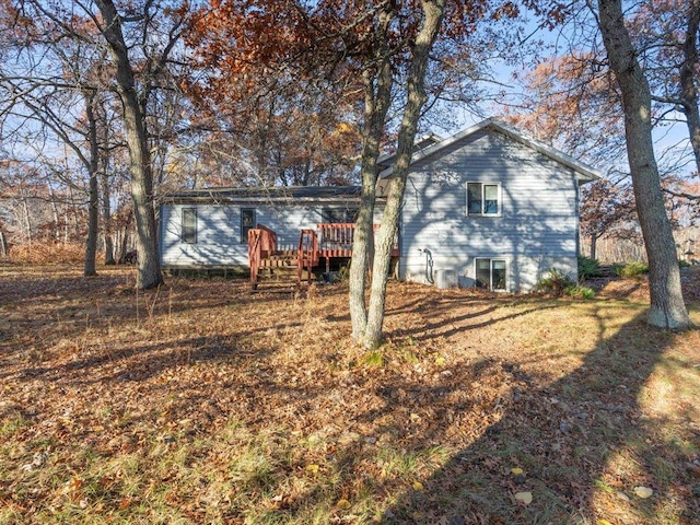 back of property featuring a yard and a deck