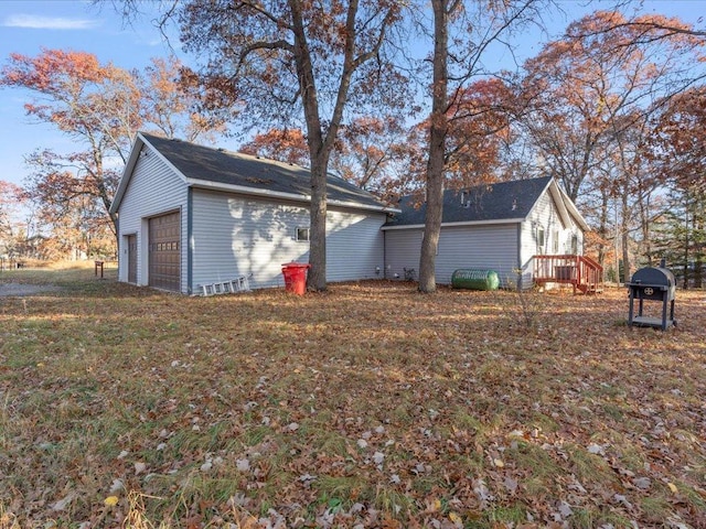 view of side of property featuring a yard and a garage