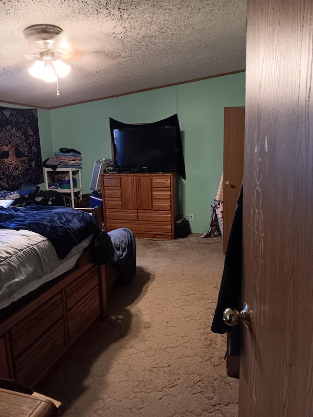 carpeted bedroom featuring ceiling fan and a textured ceiling