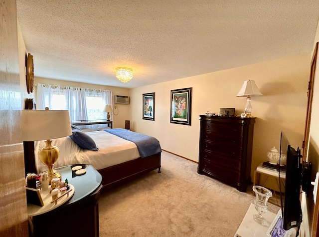 carpeted bedroom with a wall mounted air conditioner and a textured ceiling