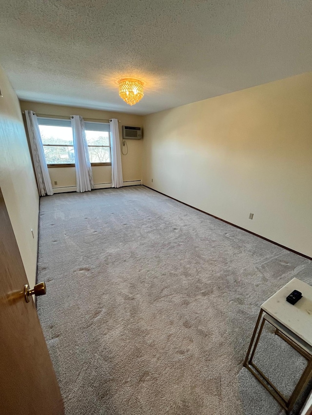 unfurnished room with light colored carpet, a wall mounted AC, and a textured ceiling