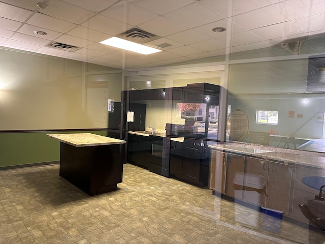 kitchen with a drop ceiling, sink, and a kitchen island