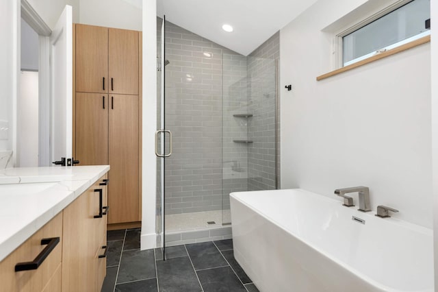 bathroom with tile patterned flooring, vanity, vaulted ceiling, and shower with separate bathtub