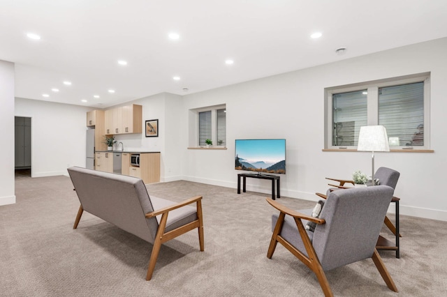 living room featuring light carpet and sink