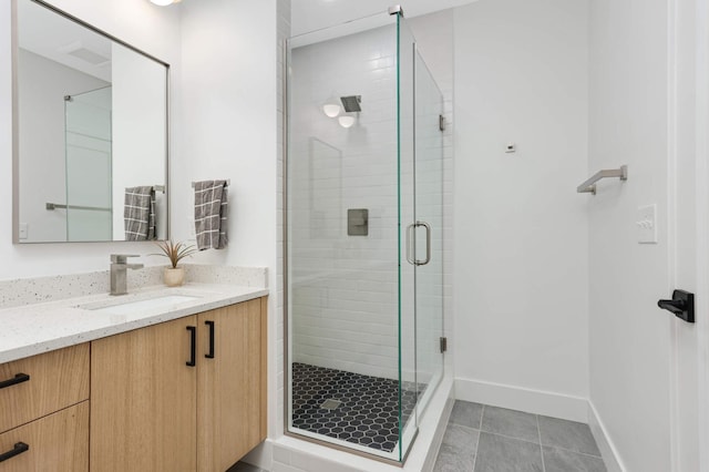 bathroom with tile patterned floors, vanity, and walk in shower