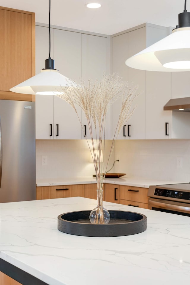 details featuring white cabinetry, stainless steel appliances, and decorative light fixtures