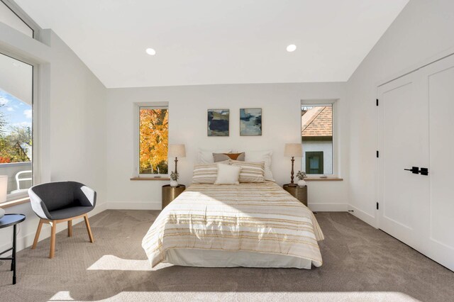 bedroom with light colored carpet and lofted ceiling