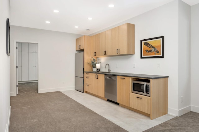 kitchen featuring light carpet, light brown cabinetry, stainless steel appliances, and sink