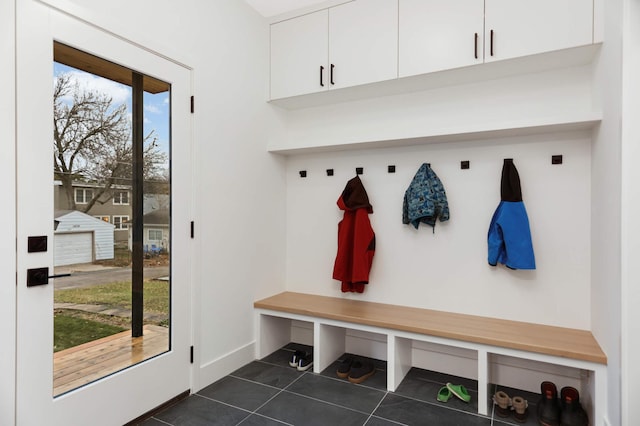 mudroom with dark tile patterned floors