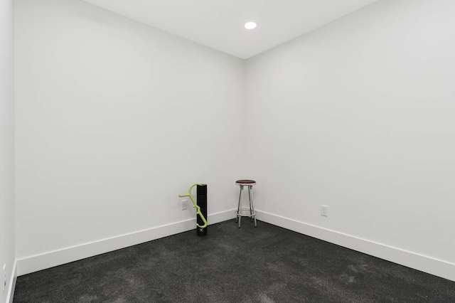 unfurnished room featuring dark carpet