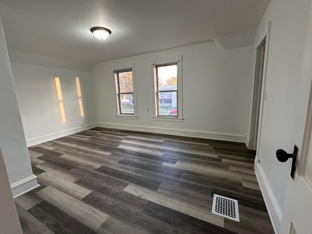 empty room with dark wood-type flooring