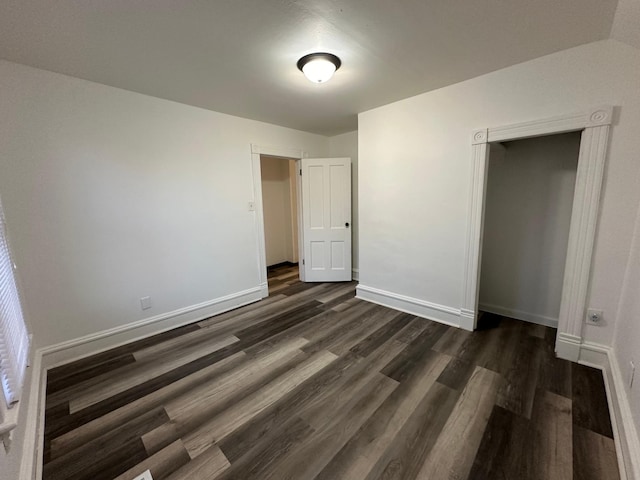 unfurnished bedroom featuring dark wood-type flooring and a closet