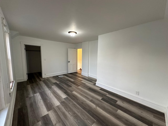 unfurnished bedroom with a closet and dark hardwood / wood-style floors