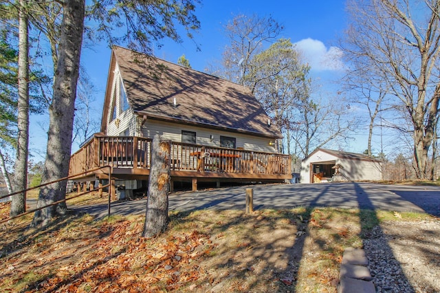 back of house featuring an outdoor structure and a deck