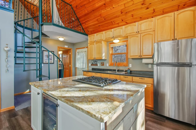 kitchen with a center island, beverage cooler, freestanding refrigerator, gas cooktop, and a sink