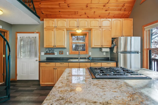 kitchen with light brown cabinets, a sink, stainless steel appliances, vaulted ceiling, and wood ceiling