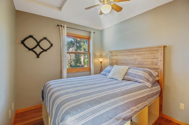 bedroom featuring wood finished floors, baseboards, and ceiling fan