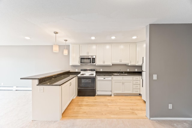 kitchen with white appliances, decorative light fixtures, kitchen peninsula, and white cabinets