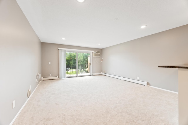 carpeted spare room featuring a wall mounted AC and baseboard heating