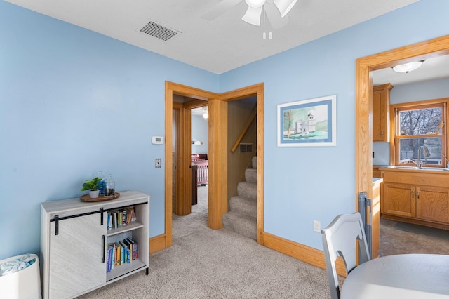 carpeted office with ceiling fan and sink