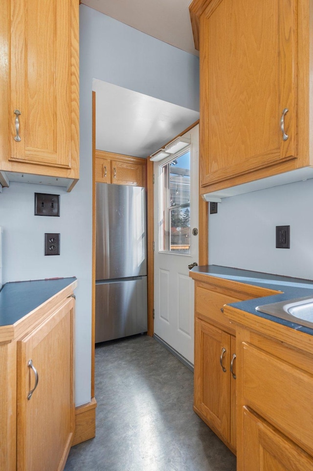 kitchen featuring stainless steel fridge and concrete floors