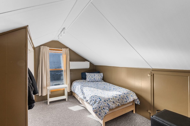 carpeted bedroom featuring vaulted ceiling and rail lighting