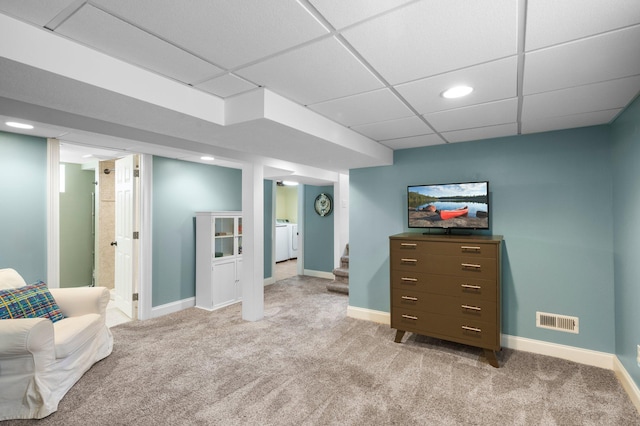 sitting room with a paneled ceiling, light colored carpet, and washing machine and clothes dryer