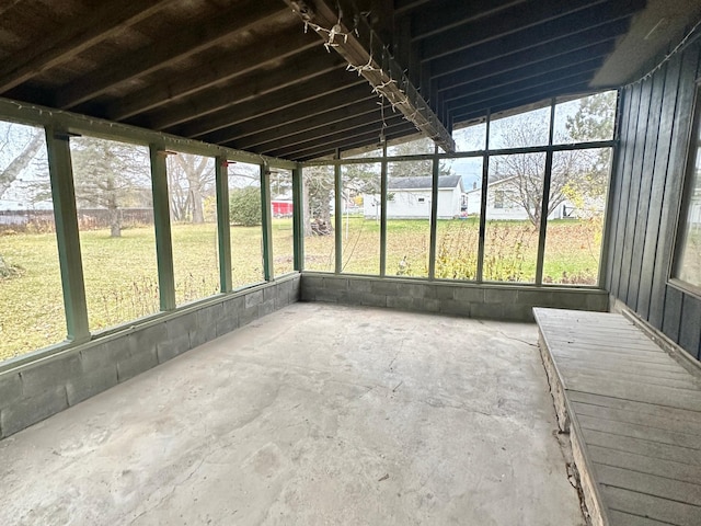 unfurnished sunroom featuring lofted ceiling and plenty of natural light