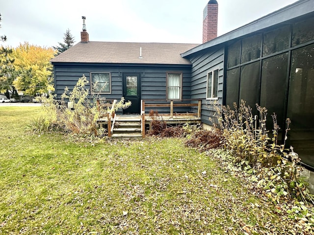 30 3rd St, Cohasset, MN 55721 - back of property with a deck, a lawn, and a chimney