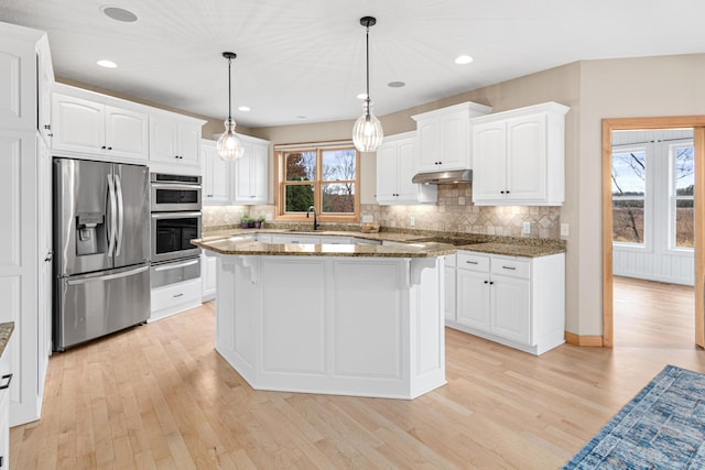 kitchen with dark stone counters, white cabinets, pendant lighting, and appliances with stainless steel finishes