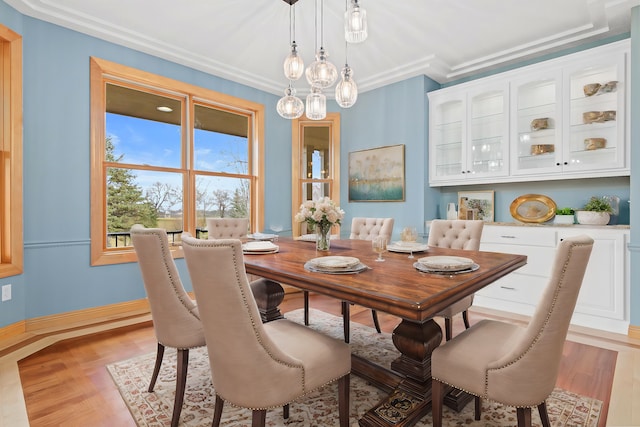 dining space featuring light hardwood / wood-style floors and crown molding