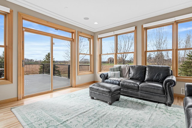 living room featuring a wealth of natural light, wood-type flooring, and ornamental molding