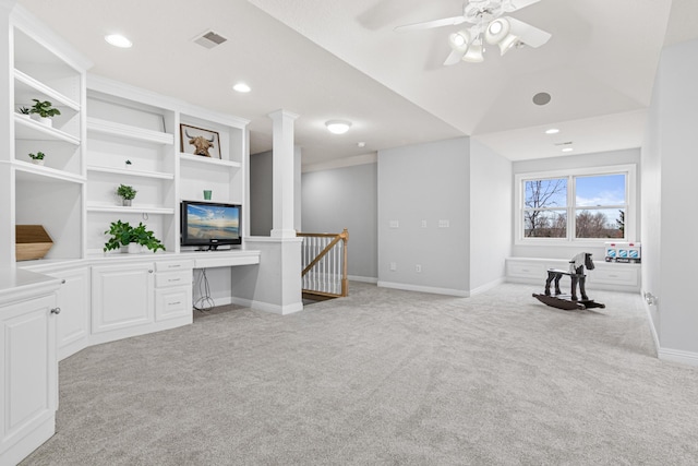 living room featuring built in desk, ceiling fan, lofted ceiling, and light colored carpet