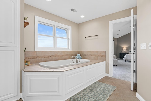 bathroom with a washtub and tile patterned floors