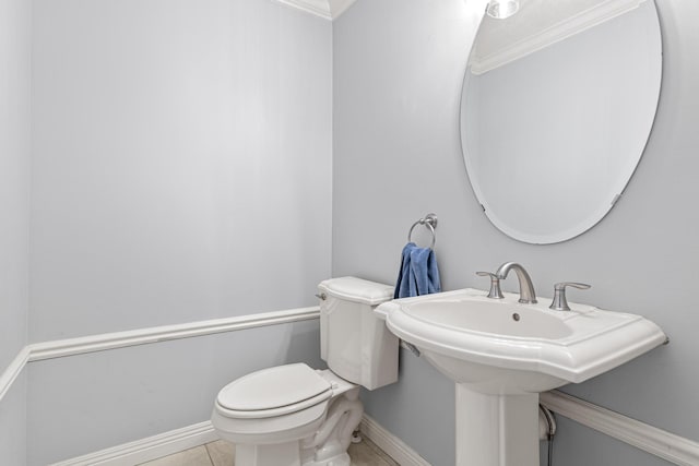 bathroom featuring tile patterned flooring, toilet, sink, and ornamental molding