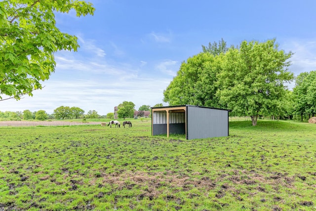 view of yard with an outdoor structure and a rural view