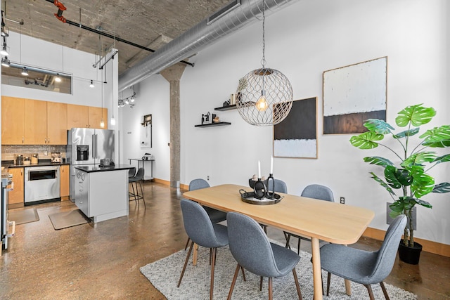 dining area featuring a towering ceiling