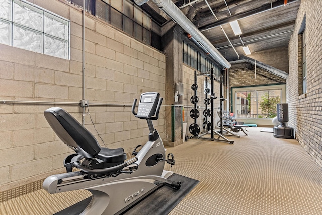 exercise area with brick wall and carpet floors