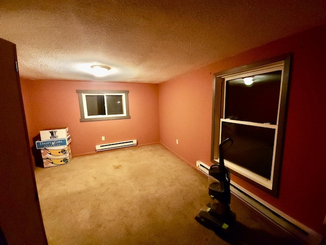 carpeted spare room featuring a textured ceiling and a baseboard radiator