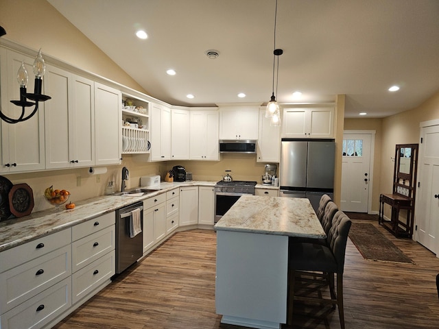 kitchen featuring stainless steel appliances, a center island, sink, exhaust hood, and decorative light fixtures